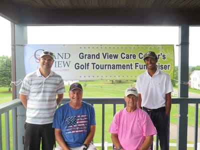 Grandview Care Center Inc., nursing home in Athens, GA — Golf tournament fundraiser participants posing under a banner