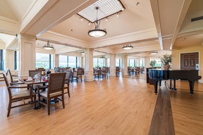 Bright dining room with tables and a piano