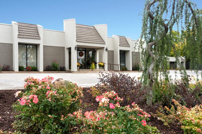Exterior view of a senior living facility with landscaped flowers