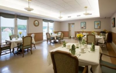 Dining area set for a meal with flowers on the tables