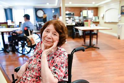 A resident enjoying time in the common area of a facility