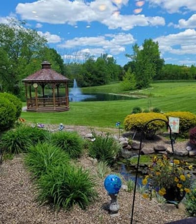 Scenic view of a gazebo by a pond with fountain