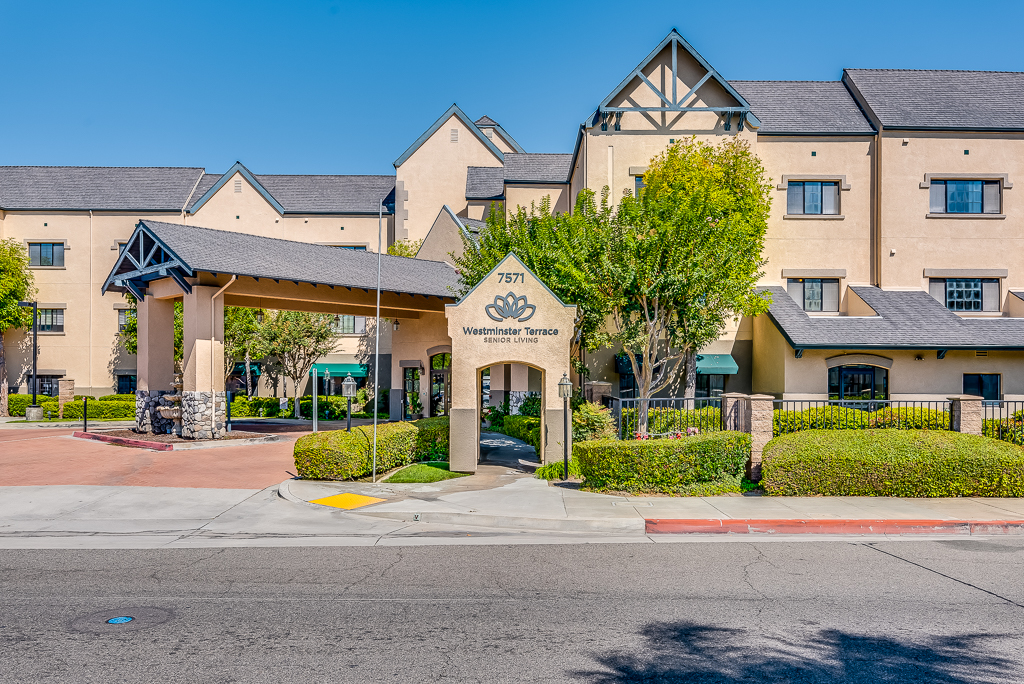 Main entrance of a senior living facility with gardens