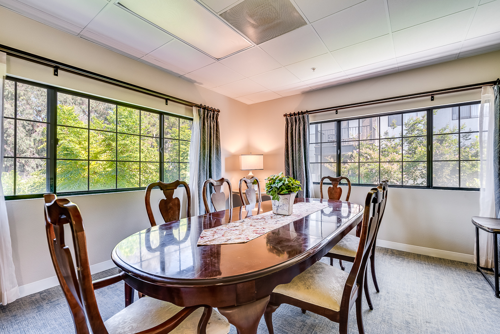 Bright dining area with large windows and wooden table