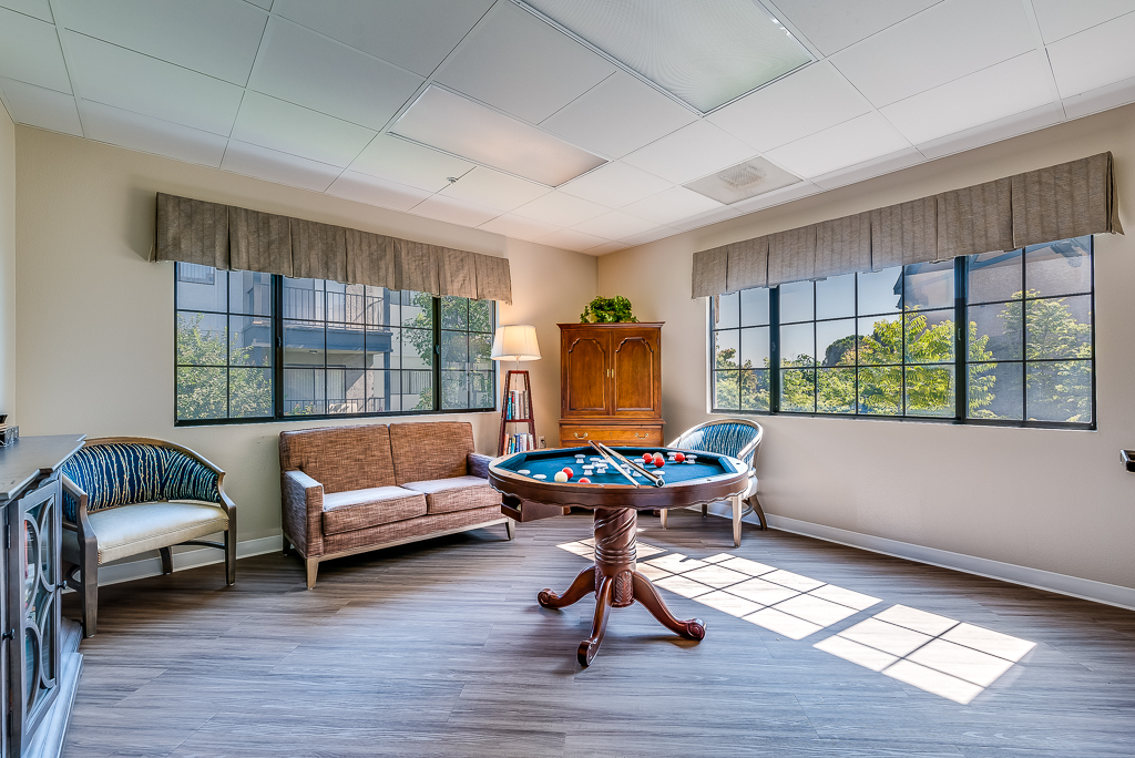 Bright common area with a billiards table and seating