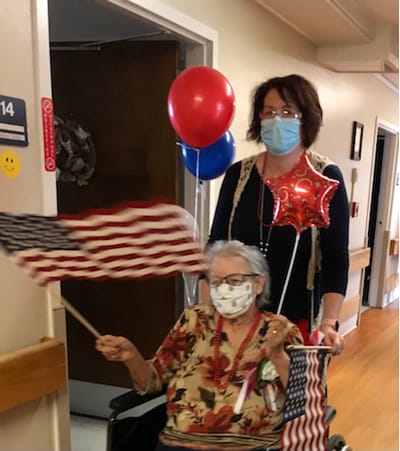 Residents celebrating with flags and balloons in the hallway