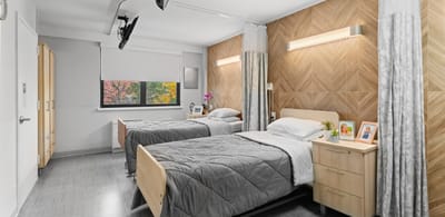 A cozy resident room with two beds and decor