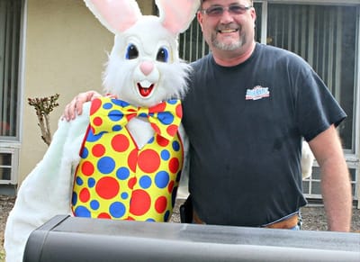 Resident and mascot posing together at an event