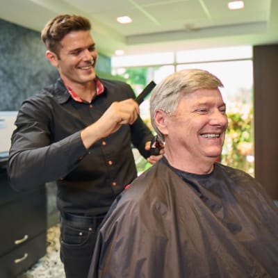 A resident enjoying a haircut in a salon