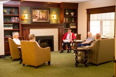 Residents engaged in conversation in a cozy lounge