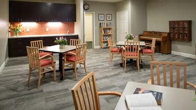 Common area with tables and chairs in a bright room