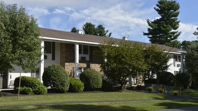 Exterior view of a senior living facility surrounded by trees