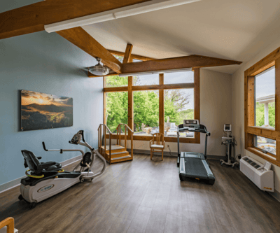 Fitness area with exercise machines and large windows
