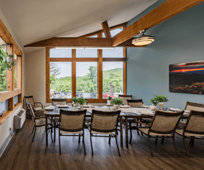 Bright dining room with large windows and tables set for a meal