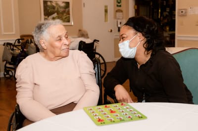 Resident and staff member enjoying a game together