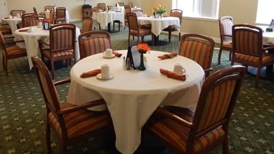 Dining room with neatly set tables and flowers