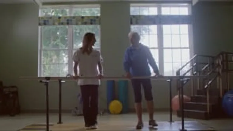 Resident participating in therapy with staff assistance
