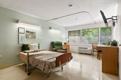 A private resident room with bed and seating area
