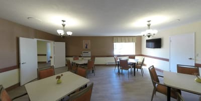 Common area with tables and chairs in a well-lit room