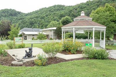 Outdoor gazebo surrounded by flowers and greenery