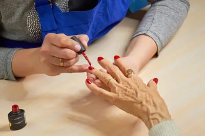 Resident receiving a manicure in a communal space.