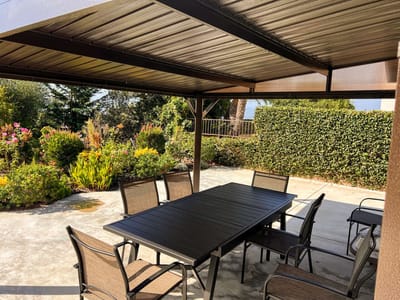 Outdoor dining area under a shaded pergola