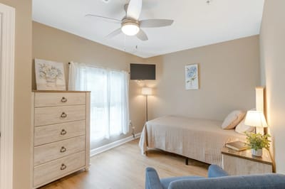 Brightly lit resident room with furniture