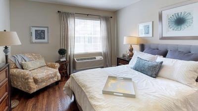 Cozy private resident room with a bed and chair
