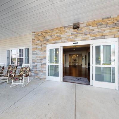 Entrance area with rocking chairs and stone façade