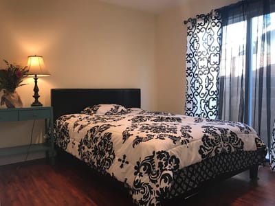 A well-decorated resident room with a bed and lamp