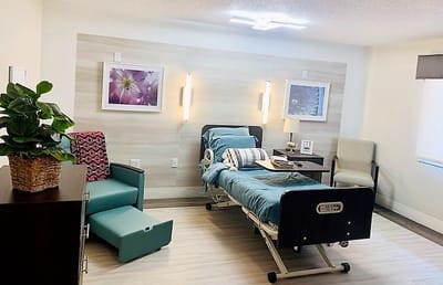 A well-furnished private resident room with a hospital bed