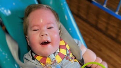 A smiling child with medical equipment in a facility