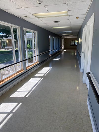 Bright, sunlit corridor with windows and seating
