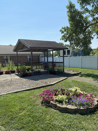 Outdoor gazebo surrounded by flowers and greenery
