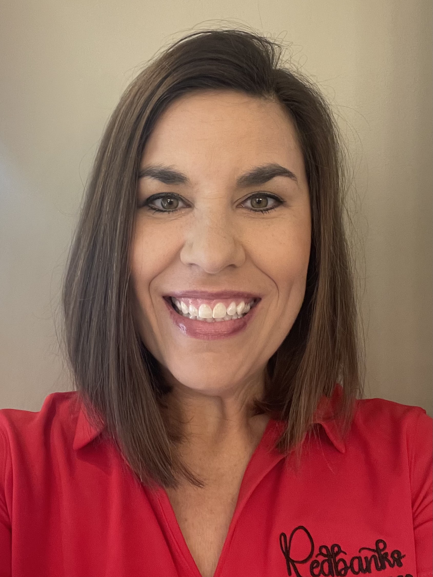 Staff member smiling in a red shirt
