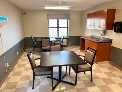 Interior of a private resident room with tables and chairs