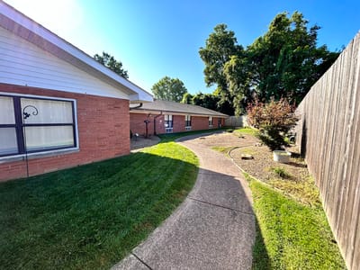 Pathway leading through landscaped outdoor area of the facility