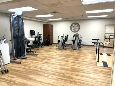 Therapy room with exercise equipment and wooden floors
