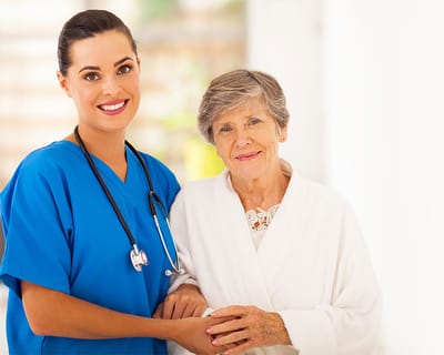A caregiver and a senior resident smiling together