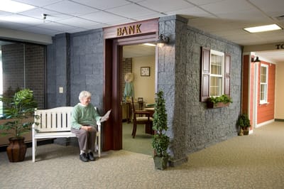 Resident reading in a well-lit interior hallway