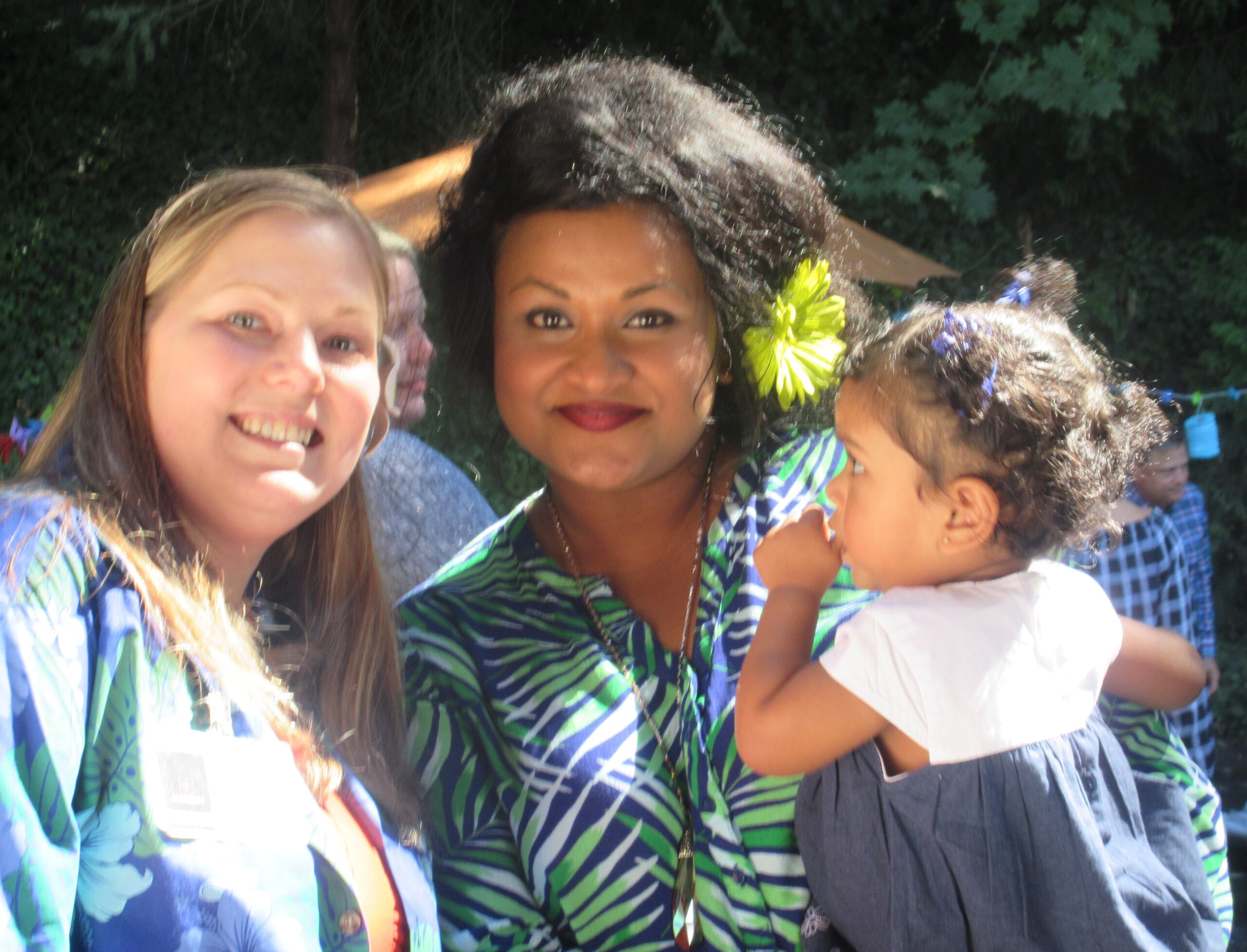 Two women and a child posing outdoors with smiles