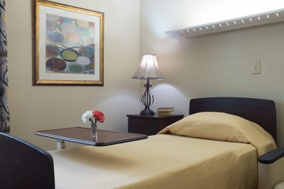 Cozy resident room with a bed and lamp