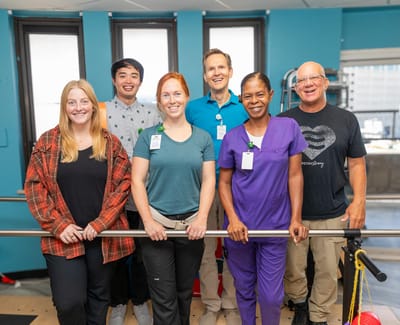 Staff members posing in a rehabilitation room