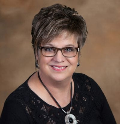 Dove Healthcare – West Eau Claire, Nursing Home in Eau Claire, WI — Smiling woman with glasses and stylish hairstyle