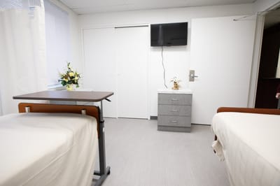 Private resident room with two beds and a TV