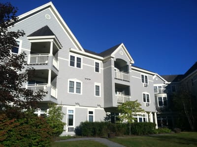 Exterior view of a senior living facility with gardens
