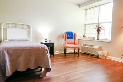 Cozy private resident room with bed and chair