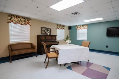 Bright common area with a piano and dining table