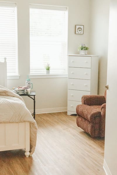 Cozy private resident room with a chair and dresser