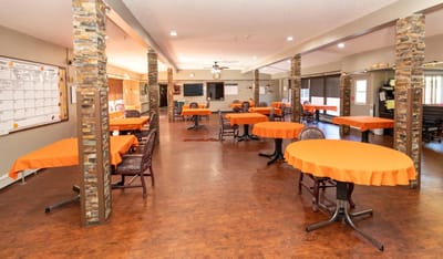 Dining area with orange tablecloths and chairs